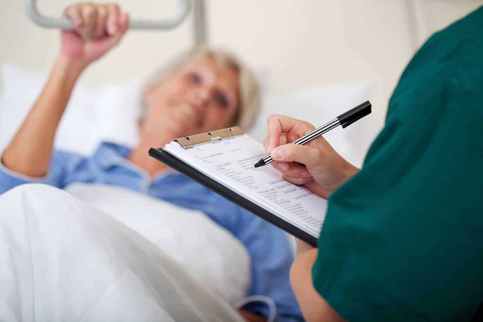 Startseite 3 Krankenschwester macht Notizen über eine Patientin auf einem Block | stockfour/shutterstock.com