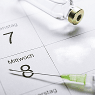 Spritze, die auf einem Kalender liegt